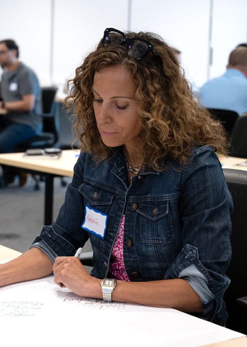 A woman writes down notes during a planning session